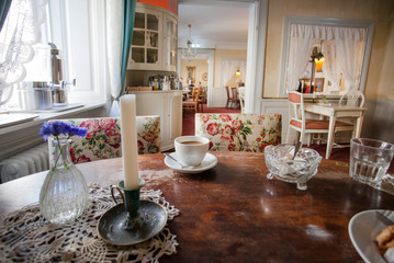 Classic interior for coffee lovers in cafe or restaurant, with vintage furniture and curtains on windows of old house.