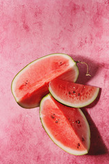 Ripe sliced watermelon over pink texture background. Flat lay, space.