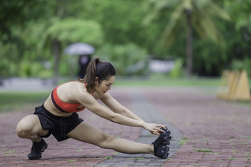 Asian sporty woman stretching body breathing fresh air in the park,Thailand people,Fitness and  exercise concept,Jogging in the park