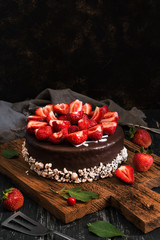 Obraz na płótnie Canvas Chocolate cake with strawberries. Dark food photography. Rustic style, selective focus.