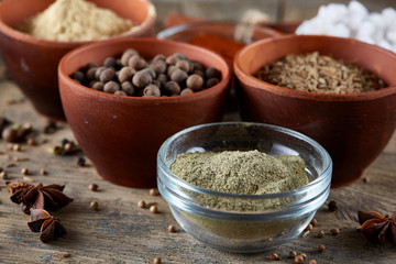 Spices in ceramic bowls on the top of wooden barrel, close-up, selective focus, shallow depth of field.