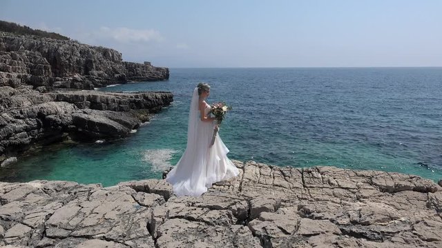 Lonely bride on coastal rocks. Adriatic Sea, Montenegro.