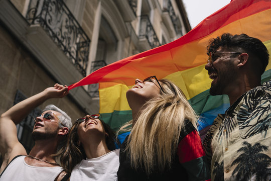 Group of friends with a flag of gay pride in the city of Madrid