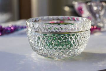 Fine quality lead crystal glass bowl with diamond-cut facets reflecting green and silver color