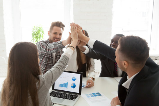 Smiling millennial colleagues giving high five, celebrating successful project startup, work team congratulating with great results or company business win, workers greeting with goal achievement.