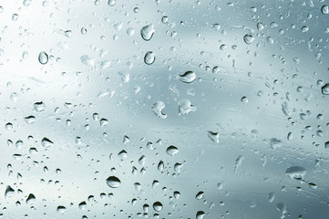 Textured background of window panes with a cloudy background. Natural pattern from a drop of rain on a cloudy background.