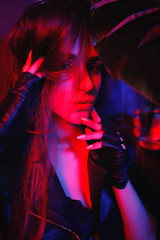 Portrait of sexy girl with long hair in leather jacket. Seated beautiful girl in black leather...