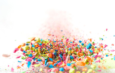 Fototapeta na wymiar Crumbs of a multicolored chalk fly on a white background. Joy, Carnival. Panorama. Game for children