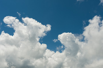 Naklejka na ściany i meble White cumulus clouds against the blue sky. The concept of weather