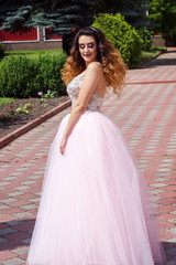 Obraz na płótnie Canvas Beautiful girl in a lush pink dress