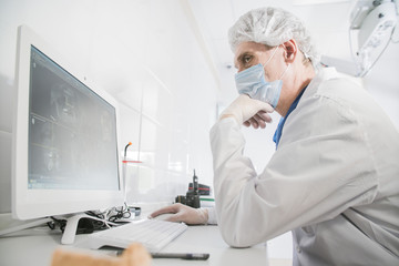 doctor dentist works in front of the monitor in the medical office