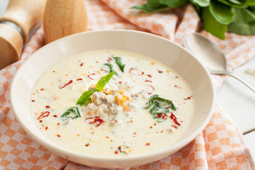 Soup with sausages, spinach, vegetables and coconut milk