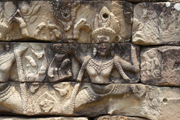 Ancient temple stone carved bas-relief in Angkor Wat. Smiling woman dancing apsara closeup.