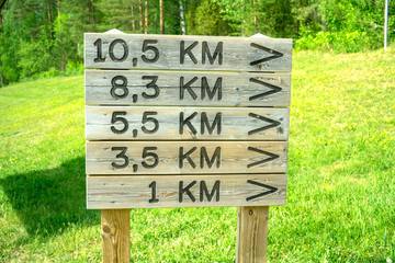 Wooden signs with arrows and distance in kilometres