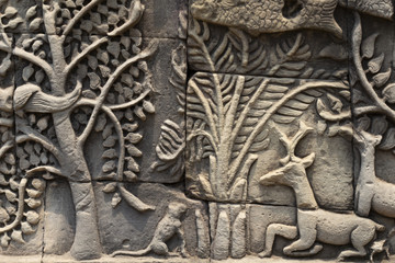 Ancient temple stone carved bas-relief in Angkor Wat. Tree and deer bas-relief closeup. Angkor Wat complex Bayon temple