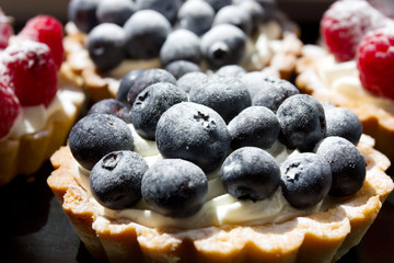 cake with blueberries and white cream on a sand tartlet