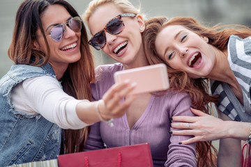 Cheerful girls with shopping bags in the city