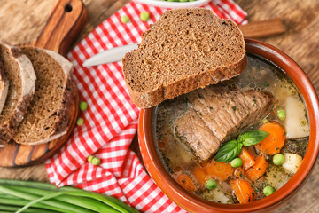 Crock pot with stewed meat on table