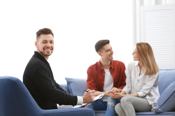 Young happy couple after therapy session with family psychologist indoors