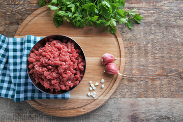 Bowl with fresh forcemeat on wooden board