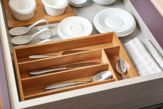 Different tableware and cutlery in drawer on kitchen