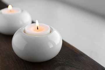 Fototapeta na wymiar Beautiful burning wax candle in holder on table