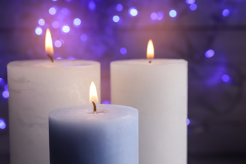 Burning wax candles on blurred background, closeup