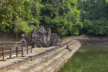 Fototapeta na wymiar Ancient temple in tropical landscape, Angkor Wat complex. Buddhist or hindu temple Neak Pean with pond and trees.
