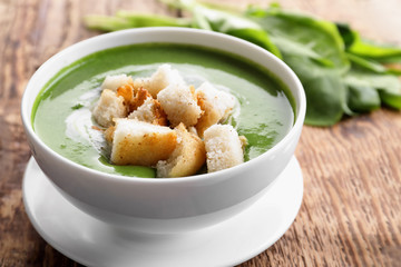 Bowl with delicious spinach soup on table