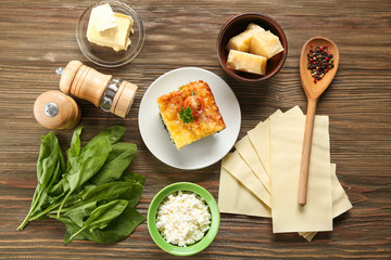 Composition of tasty lasagna with spinach on wooden background