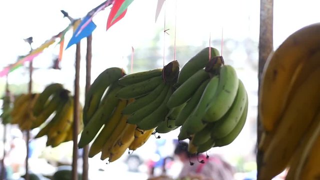 Bundles of bananas hang in the market, waiting for their customers. HD, 1920x1080, slow motion