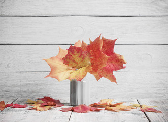 Naklejka na ściany i meble autumn yellow leaves in vase on old wooden background
