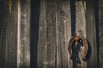 old rusty horseshoe on a dark wooden background