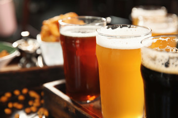 Glasses of tasty beer on wooden table, closeup