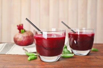 Glasses of fresh beet juice on wooden table