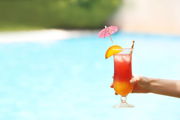 Woman holding glass with delicious cocktail outdoors