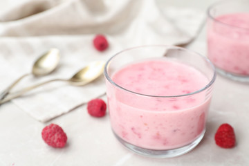 Delicious dessert with raspberries in glass on table