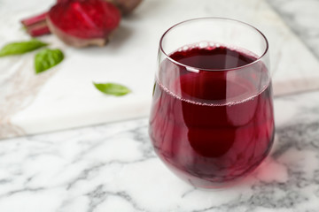 Glass with fresh beet juice on table