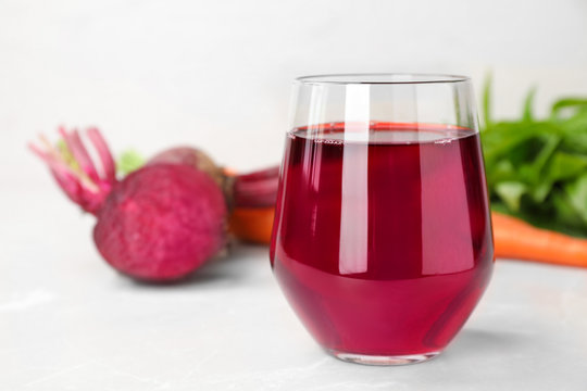 Glass with fresh beet juice on table