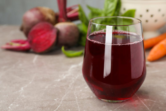 Glass with fresh beet juice on table