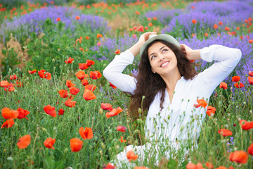 young girl is in the lavender field with red poppy flowers, beautiful summer landscape