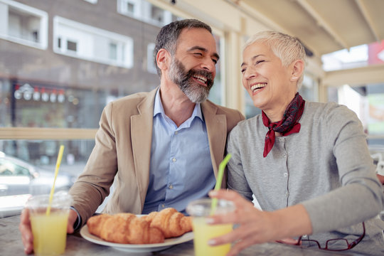 Happy Mature Couple Having Breakfast In Cafe