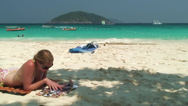 Woman Relaxes With Magazine on Beach