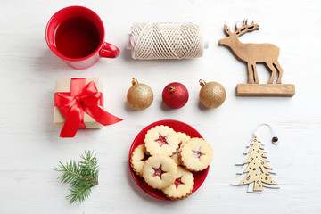 Christmas items and Linzer cookies with sweet jam on wooden background, top view