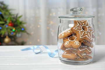 Glass jar with tasty homemade Christmas cookies on table