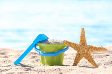 Fototapeta na wymiar Children toys on sand near sea. Beach object