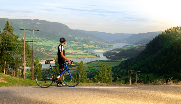 Cyclist with road bike looking at panoramic valley view