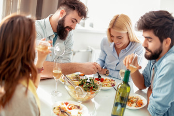 Happy friends having lunch at home