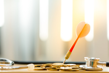 Red arrow embroidery on the gold coin and stethoscope on the desk in the office, Targeting of...