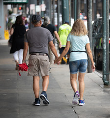 unknown happy couple holding hands for a walk downtown